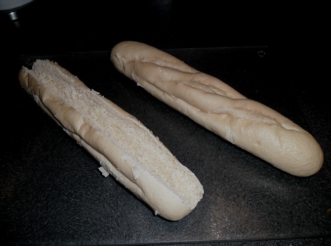 Een ingesneden en deels leeg gemaakt stokbrood, en een tweede als voorbeeld van daarvoor